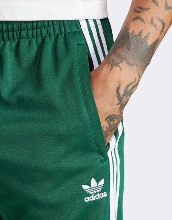 アディダス メンズ カジュアルパンツ ボトムス adidas Originals Superstar trackpants in collegiate green MID GREENの通販は