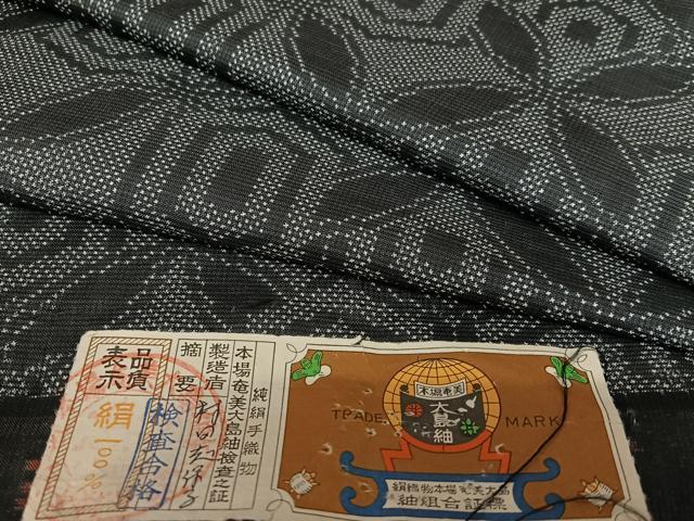 平和屋着物●本場大島紬　一元7マルキ　手織り　花七宝文　黒地　証紙付き　正絹　逸品　AAAW9091zg