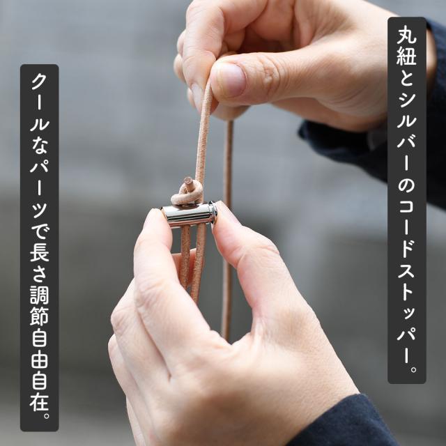 丸紐とシルバーのコードストッパー。クールなパーツで長さ調節自由自在。