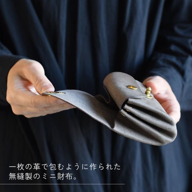 一枚の革で包むように作られた無縫製のミニ財布。
