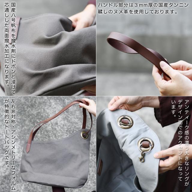 国産八号帆布を撥水剤にドボンと浸けて芯通しした両面撥水加工になります。ハンドル部分は３mm厚の国産タンニン鞣しのヌメ革を使用しております。左右非対称・アシンメトリーなフォルムが特徴的なトートバッグです。アンティーク感の漂う大きなリングがデザイン面でのアクセントになっています。