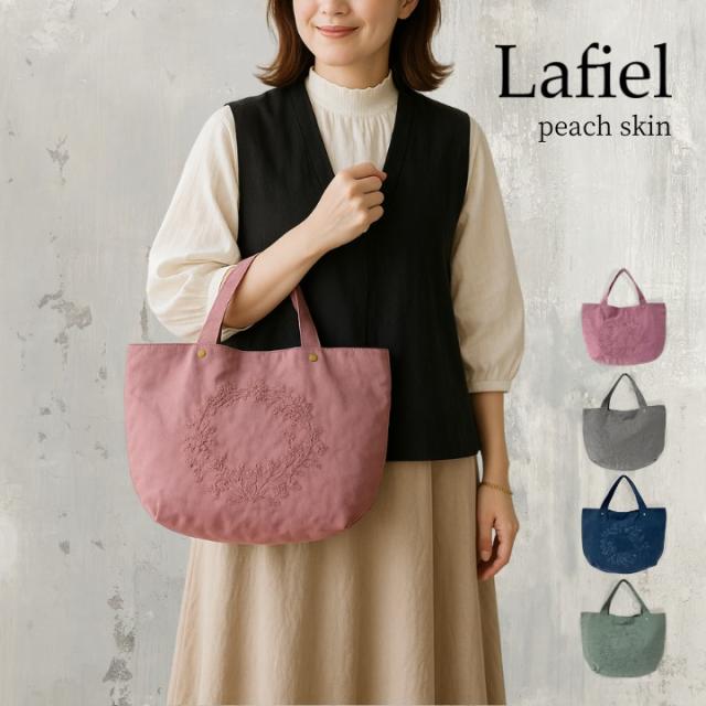 女性が持っているピンクのLafielピーチスキン風刺繍バッグ