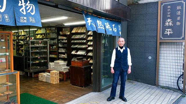 東京・浅草橋で昭和8年(1933年)から続く、刃物と天然砥石の専門卸問屋「森平」の外観と小黒章光さんです。長年培った知識と経験が、人造砥石 火シリーズに注ぎ込まれています。