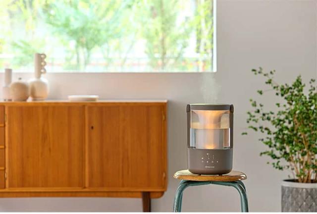 RHYTHM MIST 250加湿器のウォームグレーモデル。ミッドセンチュリー風の家具があるリビングに置かれ、部屋に溶け込むデザイン。