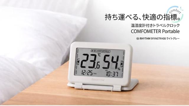 リズムの温湿度計付きトラベルクロック「COMFOMETER Portable 9YYA67RH08(ライトグレー)」。液晶画面には温度、湿度、日時、快適度アイコンが表示されている。画像右上にはキャッチコピー「持ち運べる、快適の指標。」