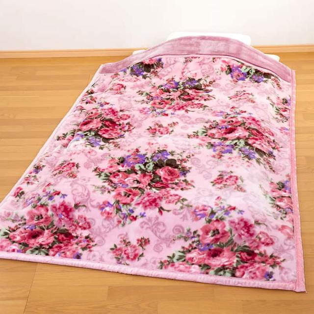 床に広げられたテイジン掛け毛布 花柄ピンク